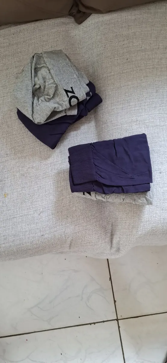 Foto de cliente com cuecas Zorba dobradas sobre sofá claro